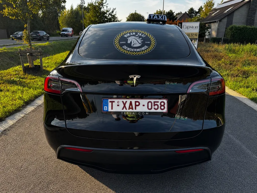 Elektrische Tesla taxi van Nikan Taxi Dendermonde met taxilicht en Nikan Taxi logo